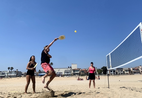 Sandy pickle player jumps for a ball