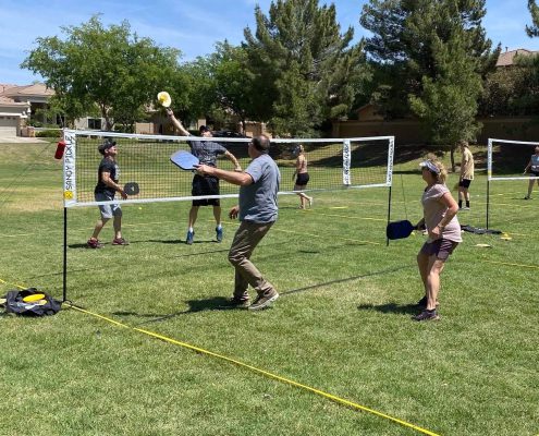 friends playing on backyard pickleball court